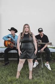 Emily Clapp posing with Dek of Hearts band members 